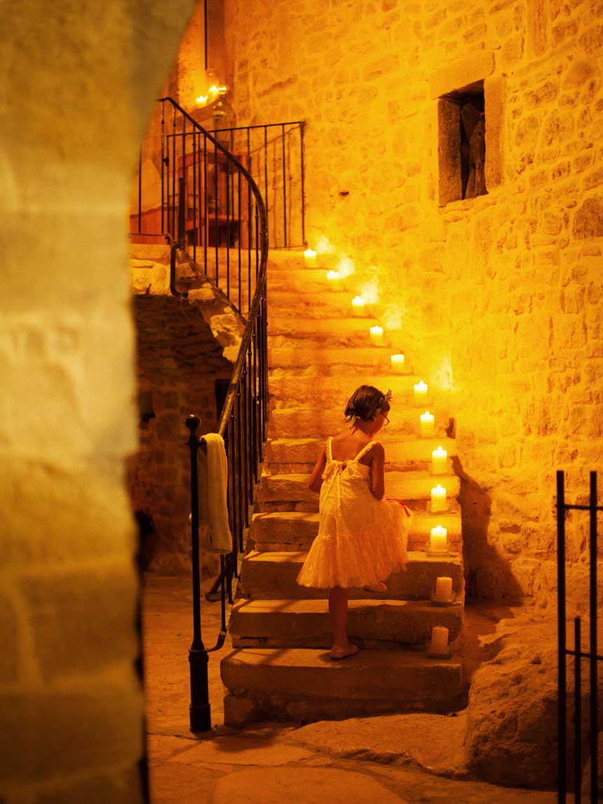 Enfant dans escalier illuminé par bougies pour des vacances en famille dans le gard 