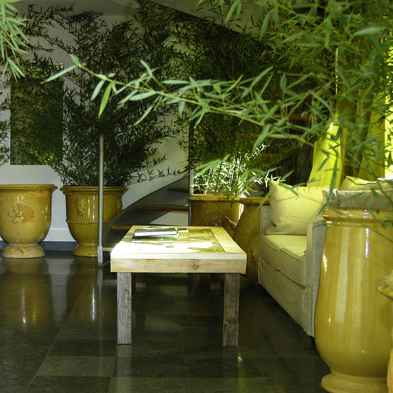 Salon intérieur chambre les orgues avec grands pots et jolie table bois pour évènements et séjous en Provence